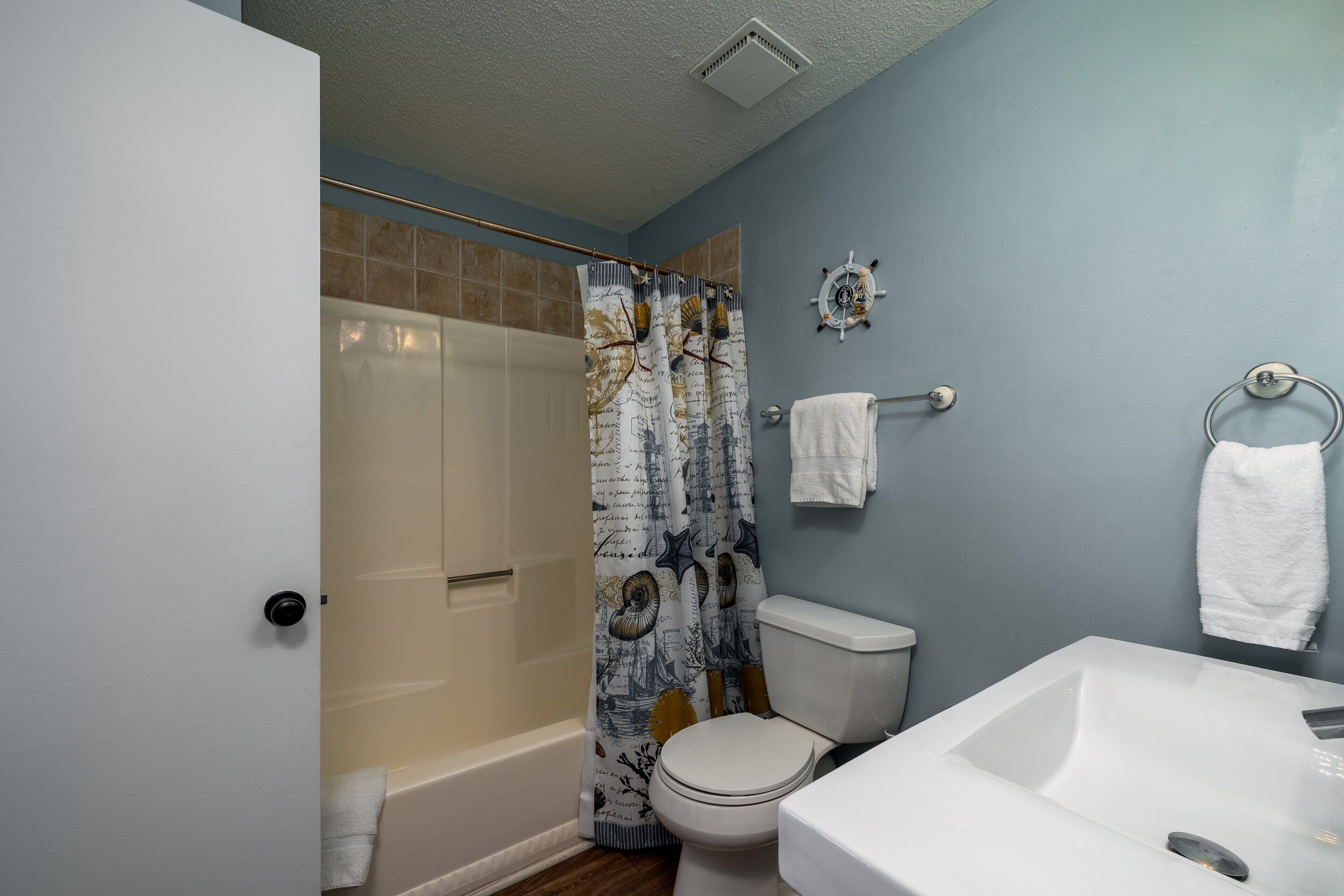 A bathroom with a bathtub, toilet, and sink.