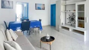 Una sala de estar moderna con un sofá, una mesa de comedor con sillas, una mesa de centro y una estantería.