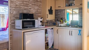 A compact kitchen with a microwave, toaster, and small refrigerator. - Mobile home in La Tremblade – Private garden, terrace, playground, and shared pool (La Tremblade (17390))