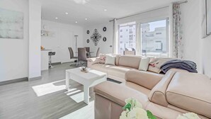 Un salon moderne avec un canapé, une table basse et un coin repas.