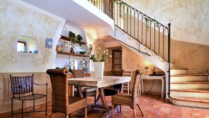 Un comedor con una mesa, sillas y una escalera.