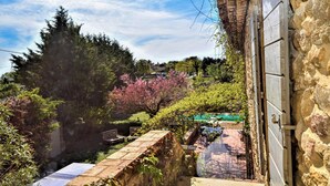 Edificio de piedra con vistas a un jardín y una piscina.