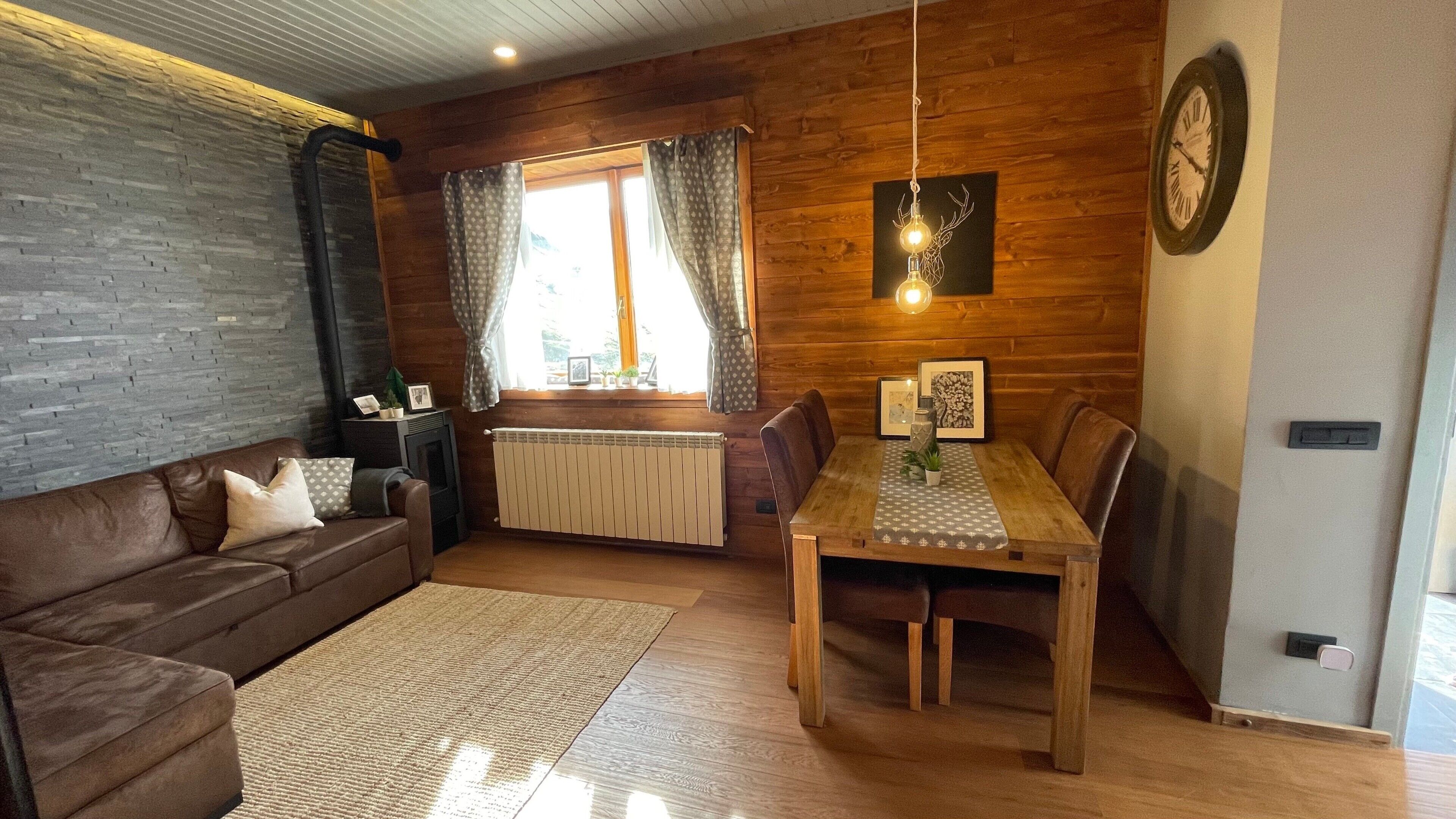 Un salon chaleureux avec un canapé en cuir marron, une table à manger en bois et une cheminée.