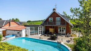 A two-story house with a swimming pool, a balcony, and a garden. - Beautiful home in Nibe with sauna (Nibe)