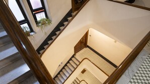 A multi-level interior with a staircase, checkered floor tiles, and a wooden railing. - Elegantis Solinda Suite Apartment with Private Terrace - Metro, Tram & Bus (Roma)