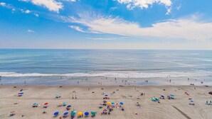 A beach with umbrellas and people.