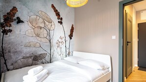 Een slaapkamer met een bed, een muurschildering en een gang.
