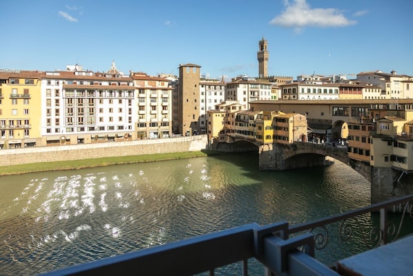 A river with buildings on both sides, a bridge, and a tower in the distance.