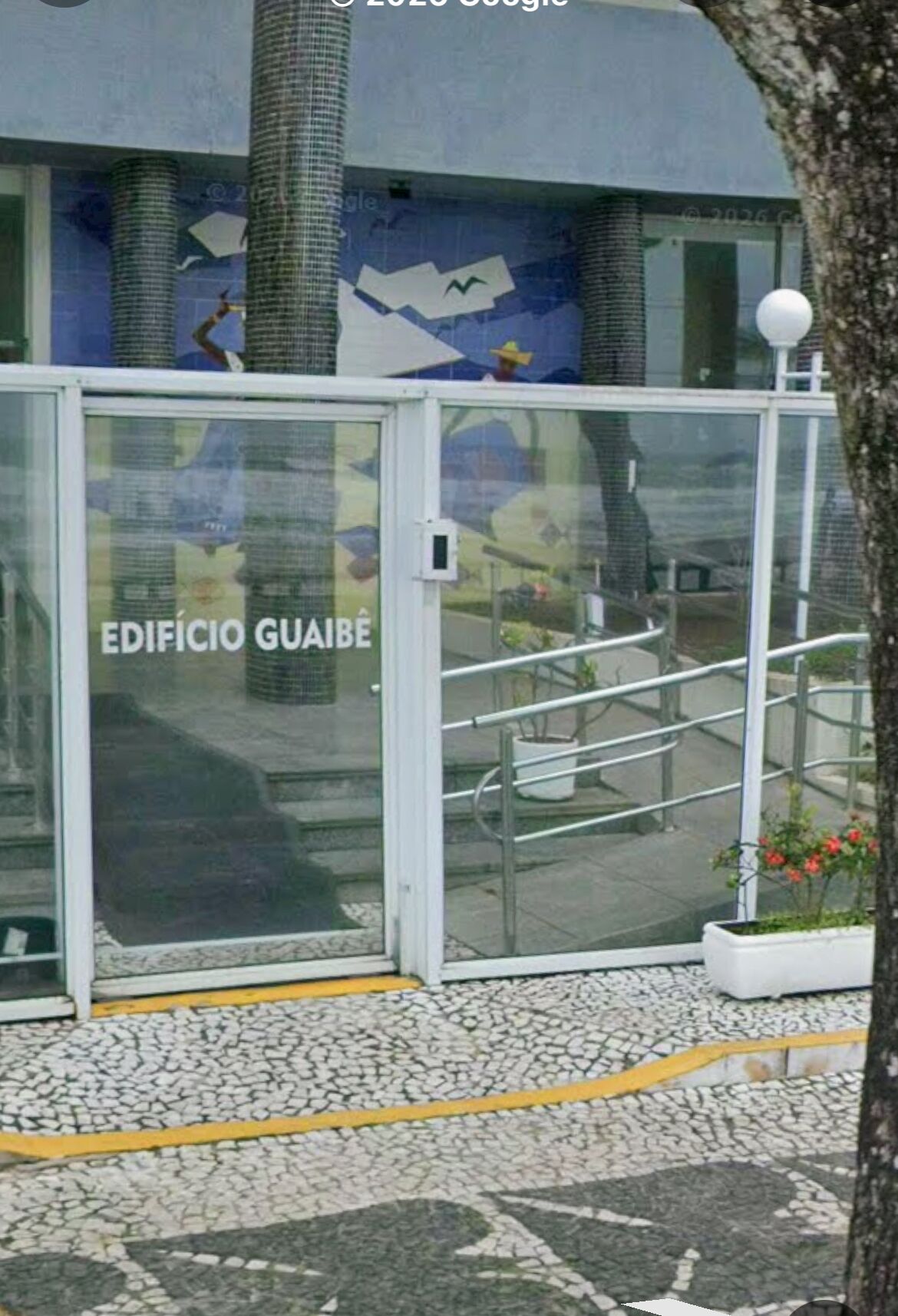 A building entrance with a glass door labeled "EDIFICIO GUÁBÉ".
