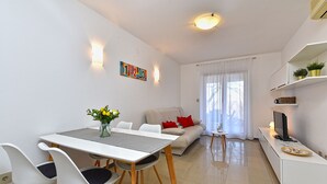 A modern living room with a dining area, a sofa, a TV, and a bookshelf. - Apartment 2372/141541 (Istria - Presika), 5000m from the beach (Presika)