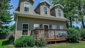 A two-story house with a front porch and a deck. - New: Charming and Cozy, Great Value! (Swanton)