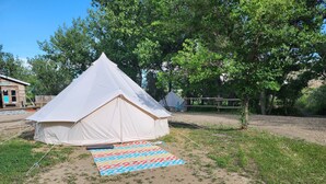 Una carpa blanca con un tapete de diseño colorido en el frente.