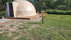 A dome-shaped tent with a wooden platform and a colorful mat. A signpost with 'D2 LAND BEFORE TIME' is visible.