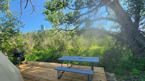 A wooden deck with a picnic table and a grill. - #D3 Rainforest Getaway Dome- 2 Dbl beds-No pets Please (Drumheller)