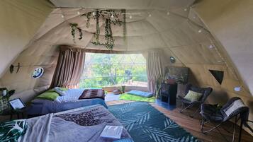 Cozy retreat with a comfortable bed, reading nook, and natural light pouring in through the large window.