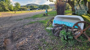 Een rustieke buitenruimte met een oud bord waarop 'BRIDGEVIEW NEWS' staat en een houten omheining.