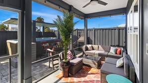 A covered patio area with outdoor furniture, a ceiling fan, and a view of the backyard. - Special Shell features 2BD/2BA w/private, fenced yard, swim spa, outdoor fireplace! (Port St. Joe)