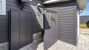 A gray building with a garage door, a satellite dish, and a mailbox. - Special Shell features 2BD/2BA w/private, fenced yard, swim spa, outdoor fireplace! (Port St. Joe)