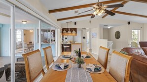 A dining area with a wooden table, chairs, and a ceiling fan.