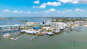 A marina with multiple docks, a bridge, and buildings with commercial establishments.