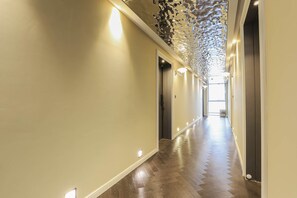 A long, narrow hallway with a wooden floor and light-colored walls. - Brown-dot Hotel Haeundae (Busan)