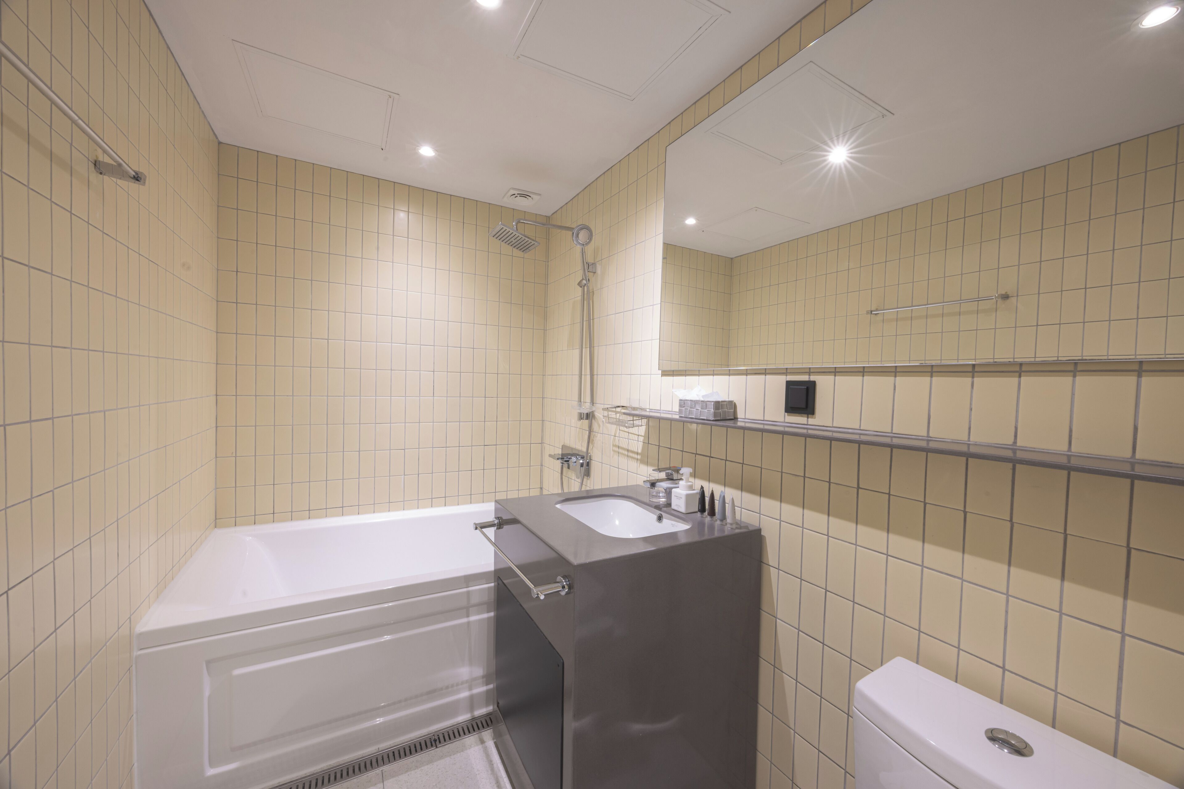 A modern bathroom with a bathtub, sink, and toilet.