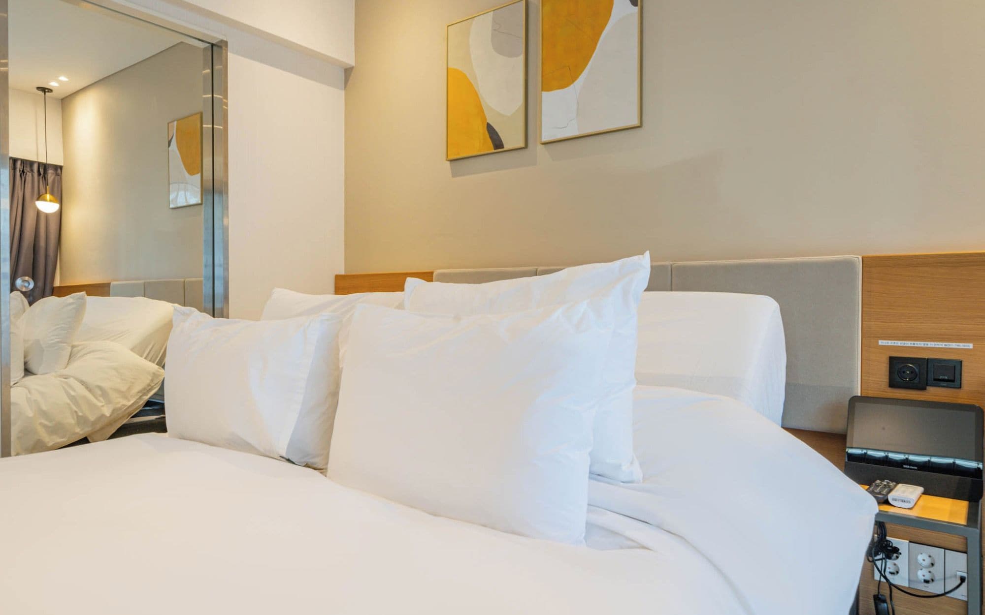 Habitación de hotel con una cama grande, una mesita de noche con lámpara y una obra de arte en la pared.