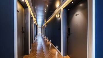 A hotel corridor with a wooden floor, dark walls, and doors numbered 506.