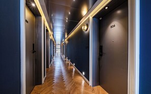 A hotel corridor with a wooden floor, dark walls, and doors numbered 506. - Brown-dot Hotel Haeundae (Busan)