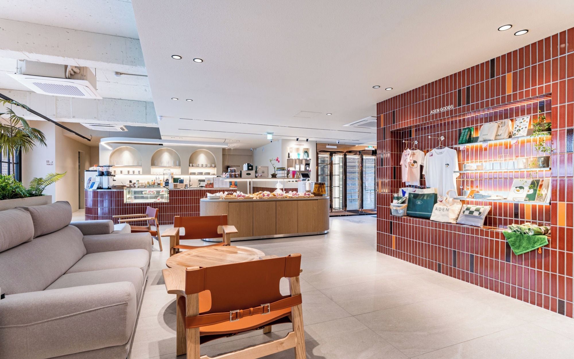 Un intérieur moderne comprenant un espace salon, un comptoir avec présentoir et un mur orné d’un motif en réseau.