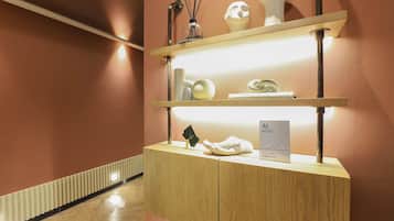 A hotel reception desk with a wooden finish, a glass display case, and a sign indicating the hotel name.