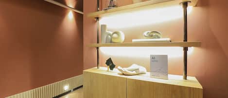 Un comptoir d’accueil en bois, une vitrine et une enseigne indiquant le nom de l’hôtel.