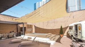 An outdoor patio with a pool, lounge chairs, and a white RV parked nearby. - Brown-dot Hotel Haeundae (Busan)