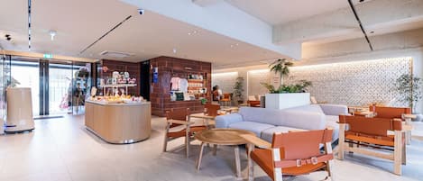 Un interior moderno con zona de estar, estación de café y pared de ladrillo.