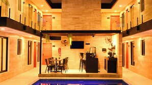 A modern indoor pool area with a bar and seating. - Hotel 28 (Cancun)