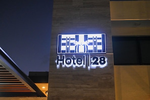 Et hotelskilt med palmer og nummer 28.