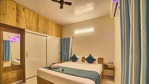 Ein Schlafzimmer mit Bett, Nachttisch, Spiegel, Kleiderschrank und Deckenventilator.