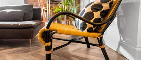 A chair with a woven seat and backrest, featuring a black and white polka dot pattern.