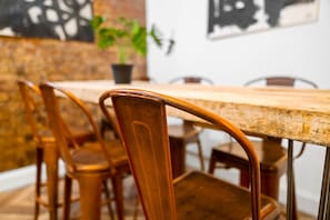 Un comedor con una larga mesa de madera y sillas de metal.