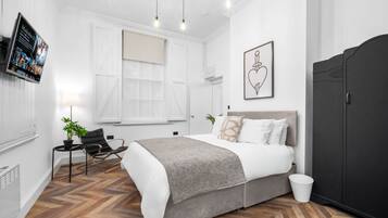 A modern bedroom with a bed, a desk, a chair, and a wardrobe.