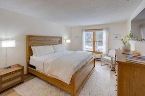 A bedroom with a wooden bed, bedside tables, a desk, and a chair. - Deer Park-Shuttle-Amenities- Fireplace (Woodstock)