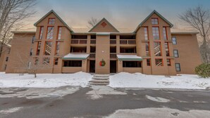 A multi-story building with a symmetrical facade, balconies, and a central entrance. - Deer Park-Shuttle-Amenities- Fireplace (Woodstock)