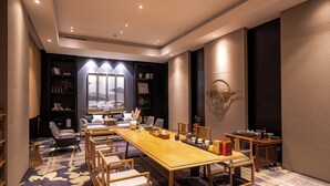 A conference room with a long table, chairs, and a bookshelf. - Xingyi Chain Hotel Jiangxia Metro Station (Guangzhou)