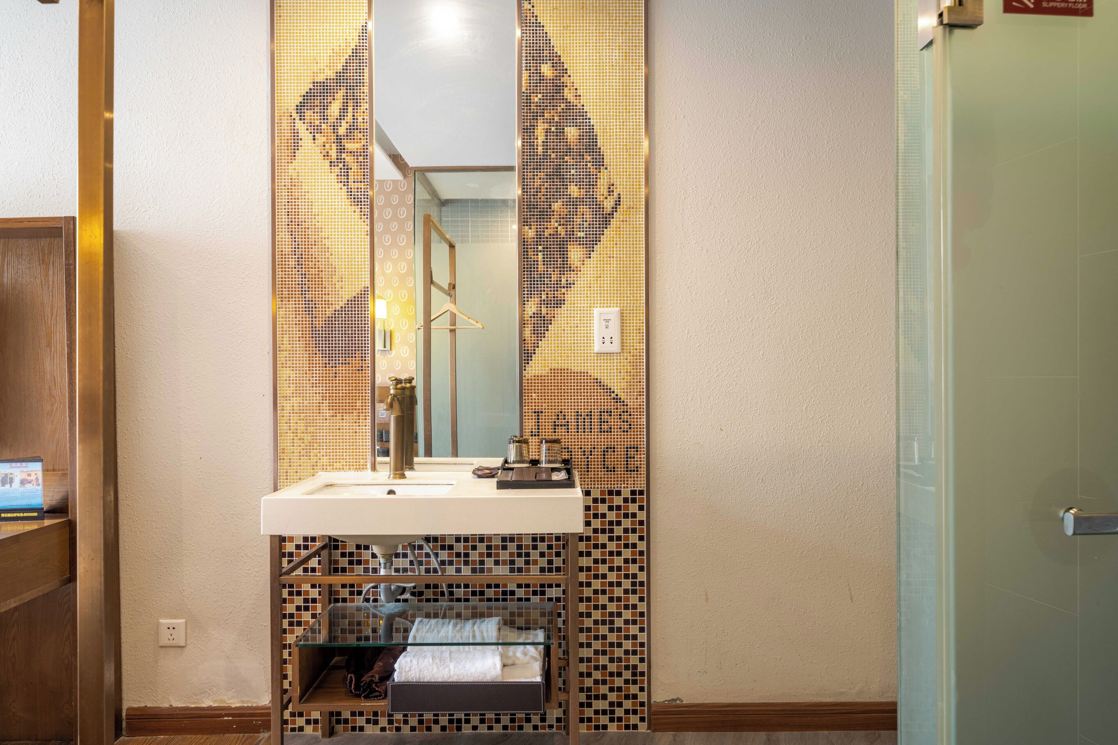A bathroom with a sink, mirror, and tiled walls.
