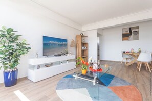 Relax in this stylish living room with a flat-screen TV, entertainment unit, and comfortable dining area.