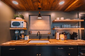 Mikrovågsugn, kaffe- och tebryggare, grytor/köksredskap och matbord