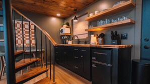 A modern kitchen with wooden shelves, a microwave, and a sink. - Edinburgh Escape | Hot Tub, Sauana + Fire Pit + Grill (Apple Creek)