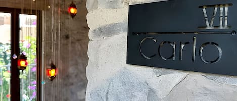 A stone wall with a metal plaque reading "Villa Carlo".
