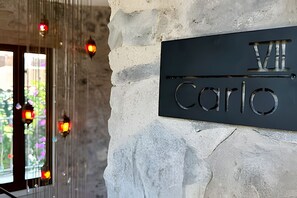 A stone wall with a metal plaque reading "Villa Carlo".