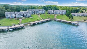 Ein am See gelegenes Hotel mit mehreren Gebäuden, einem Steg und gepflegten Rasenflächen.